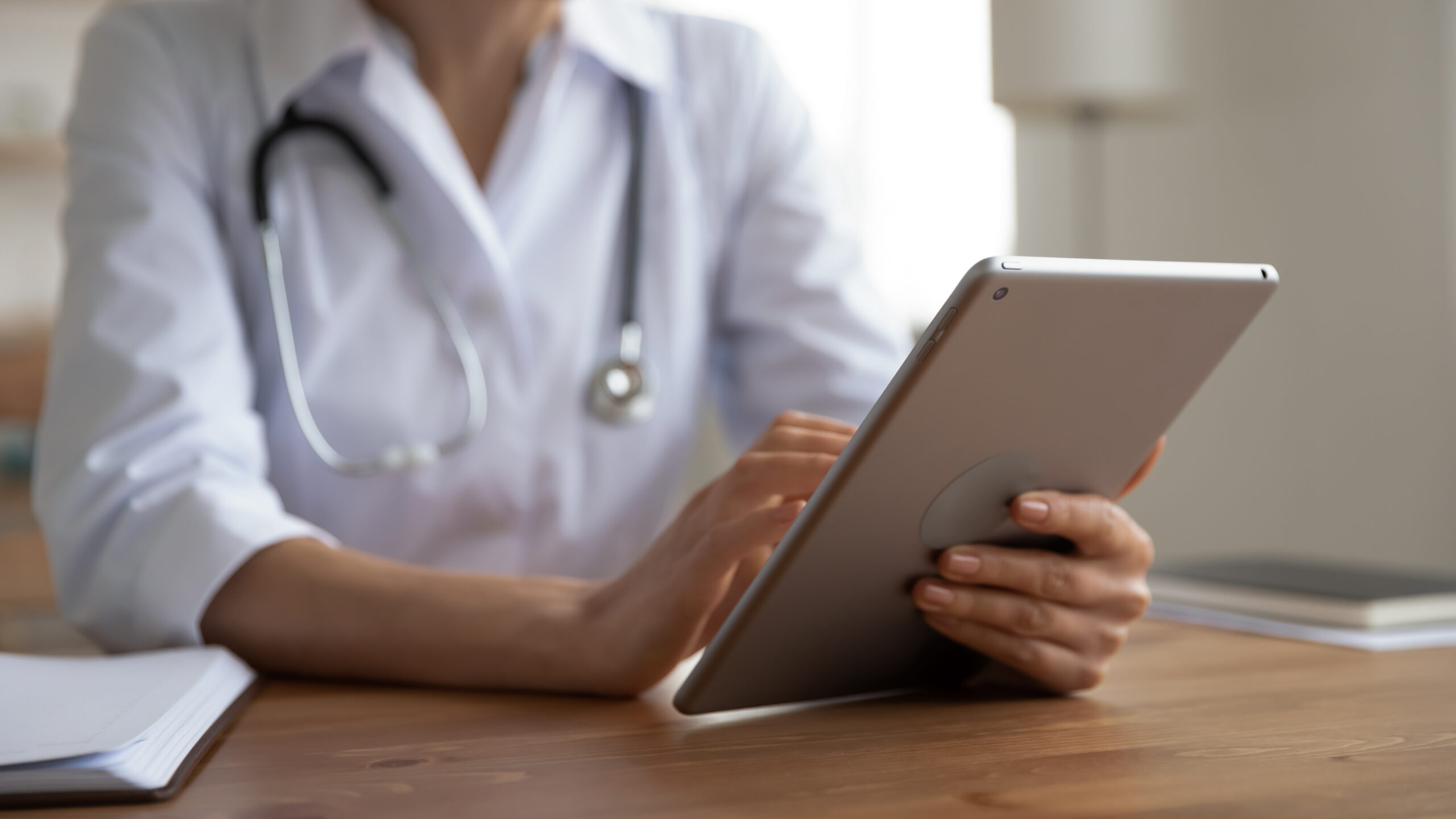 Female,Doctor,Physician,Wearing,White,Coat,Holding,Modern,Digital,Tablet